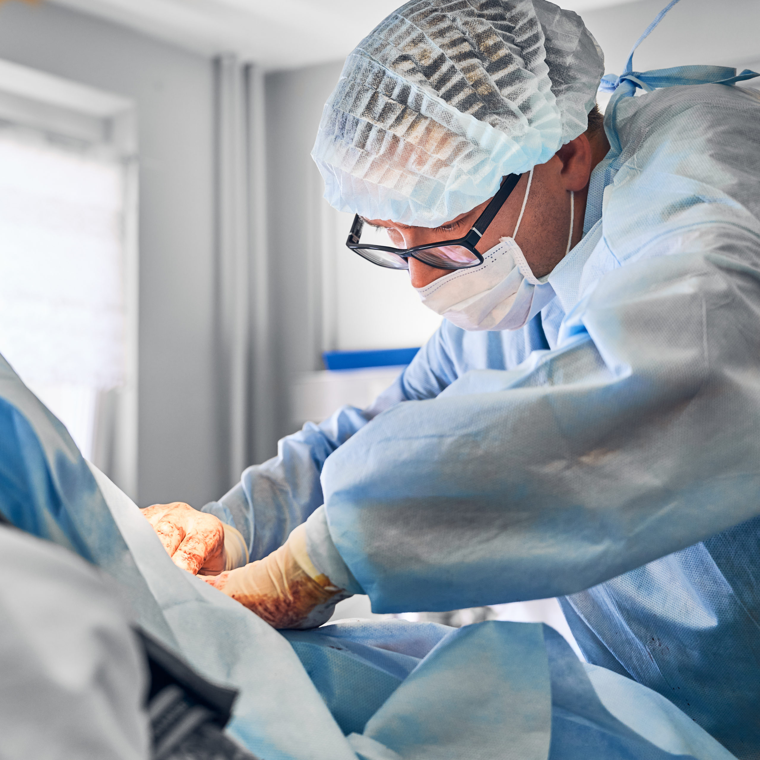 Male doctor doing abdominoplasty surgery in operating room